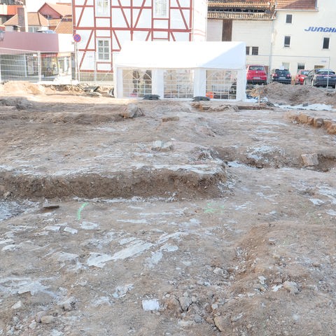 Links im Bild Nikolaiplatz in Schwege von oben und rechts im Bild Ausgrabungsdetail mit Schädel und Rippenknochen