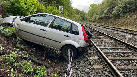 Auto liegt auf Schottersteinen direkt am Bahngleis