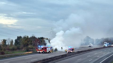 Feuerwehr auf der Autobah neben brennendem beziehungsweise rauchendem Auto