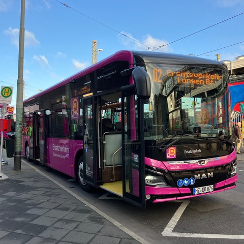 Ein Bus steht am Frankfurter Hauptbahnhof. Menschen in gelben Warnwesten stehen für Auskünfte bereit.