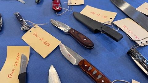 Mehrere sichergestellte Messer liegen auf einem Tisch 