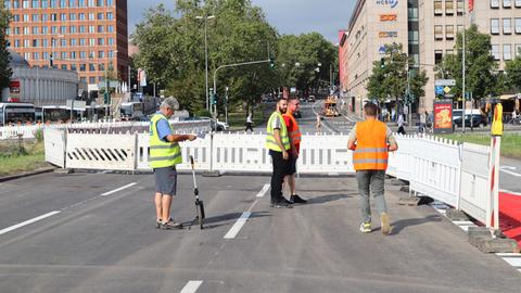 Baustellenabsperrung und Arbeiter an der Straße