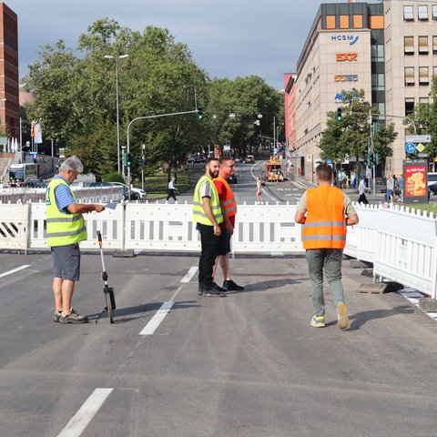 Baustellenabsperrung und Arbeiter an der Straße