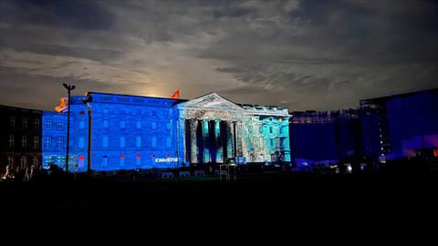 Das Schloss Wilhelmshöhe leuchtet in blau und grün. Dies Fassade wird angestrahlt.