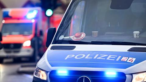 Ein Polizeiauto und ein Rettungswagen mit Blaulicht.