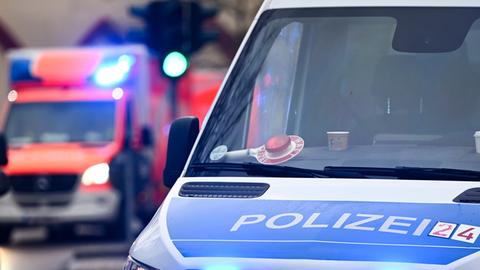 Ein Polizeiauto und ein Rettungswagen mit Blaulicht.