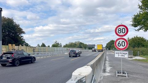 Foto: Blick auf eine Autobahn mit fahrenden Autos vom Seitenstreifen. Am rechten Rand stehen Geschwindigkeitsbegrenzungsschilder.