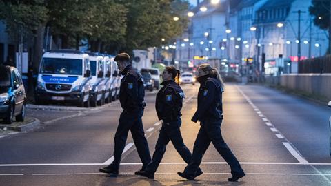 Drei Polizisten gehen über Straße