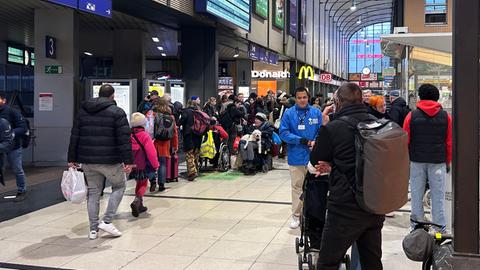 Vor dem Infopoint im Bahnhof Kassel-Wilhelmshöhe bildet sich eine Schlange von Reisenden, die Reisealternativen suchen. 