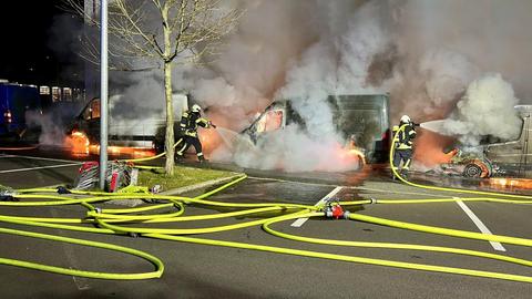 Feuerwehrleute löschen brennende Transporter