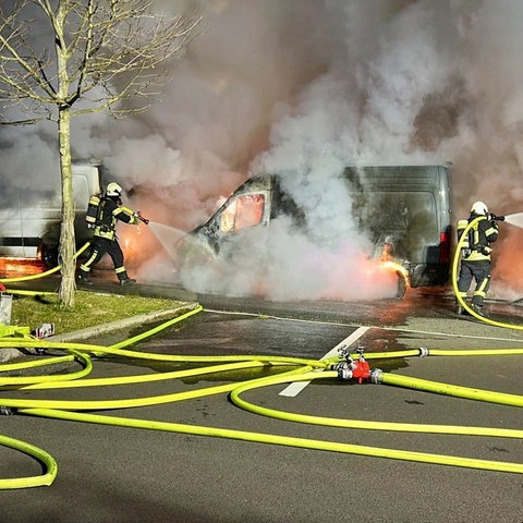 Feuerwehrleute löschen brennende Transporter