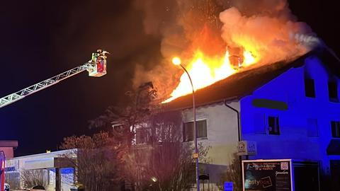 Nachtaufnahme - das Dachgeschoss eines Wohnhauses steht in Flammen.