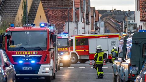 Feuerwehrautos und Feuerwehrleute in einer Straße in Eltville mit kleinen Wohnhäusern mit roten Dächern