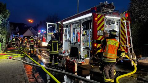 Ein Feuerwehrauto steht vor einem Haus, in dem es gebrannt hat.