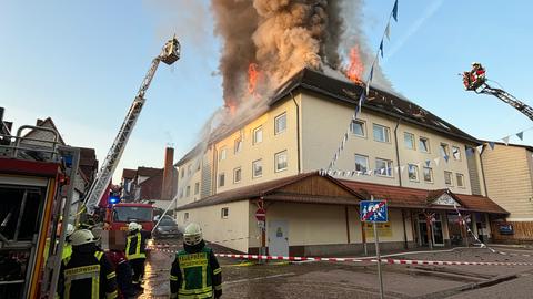 Flammen und Rauch aus Dach eines Hauses, viele Feuerwehrkräfte