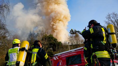 Einsatzkräfte der Feuerwehr vor dem brennenden Haus in Idstein