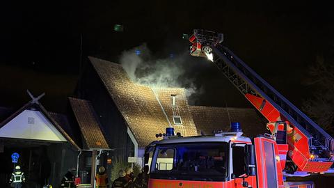 Rauch steigt aus Dach auf, Feuerwehr löscht mit Drehleiter