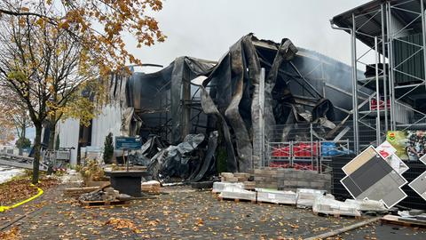 Eine teilweise eingestürzte Lagerhalle, teilweise verkohlt.