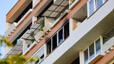 Ruß und zerborstene Fensterscheiben sind zu sehen von außen. 