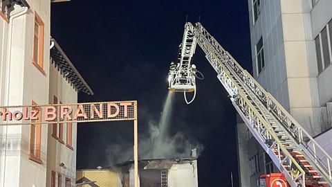 Feuerwehrleute bei Löscharbeiten unter Einsatz einer Drehleiter