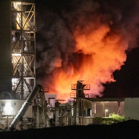 Großbrand in einem Zementwerk in Großenlüder-Müs, orangefarbener Rauch steigt hinter Hallen auf