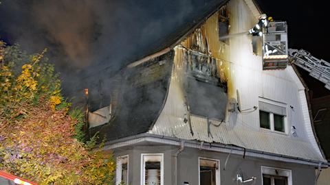 Ein Feuerwehrmann löscht ein Haus