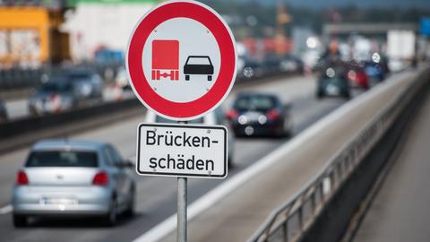 Schild "Brückenschäden" auf Brücke mit Verkehr