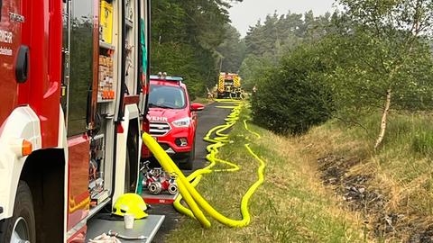 Feuerwehrautos im Wald, lange Wasserschläuche