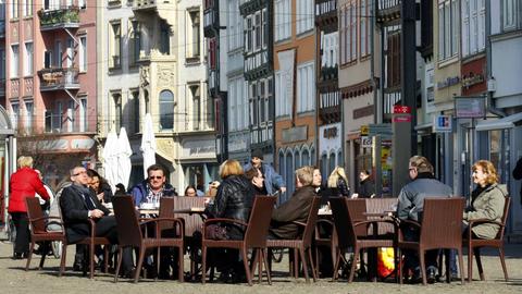 Menschen sitzen in Straßencafe