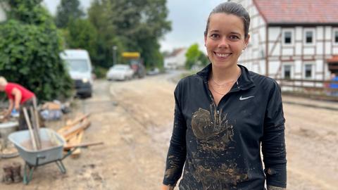 Frau mit Matsch auf dem T-Shirt steht auf Straße