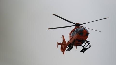 Ein orangener Rettungshubschrauber am Himmel