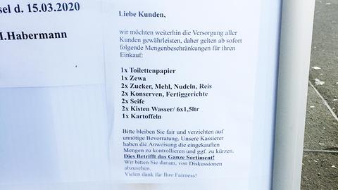 Das Foto zeigt einen Aushang vor einem Supermarkt vom Ladenbetreiber, auf dem steht, dass ab sofort nur noch Höchstmengen von bestimmten Produkten abgegeben werden.