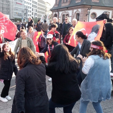 Demonstranten tanzen und schwenken Fahnen an der Frankfurter Hauptwache.