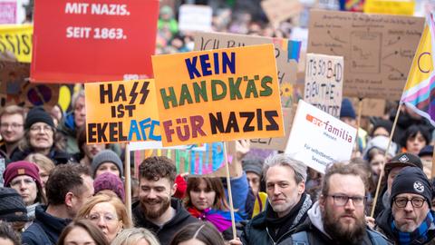 Demonstrierende auf dem Römerberg mit selbstgemalten Plakaten.