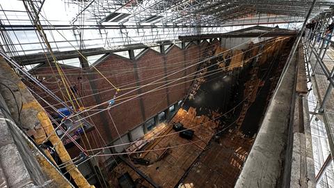 Ein Baugerüst ist der provisorische Dachstuhl der Elisabethkirche, durchs Kirchenschiff sind Seile für die Kletterer gespannt, die die Bauarbeiten machen