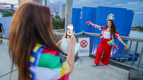 Zwei Frauen machen auf der Friedensbrücke, mit der Fanzone im Hintergrund, Fotos. 