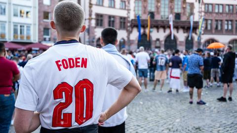 Fan des englischen Spielers Foden mit entsprechendem Trikot steht auf dem Römerberg in Frankfurt