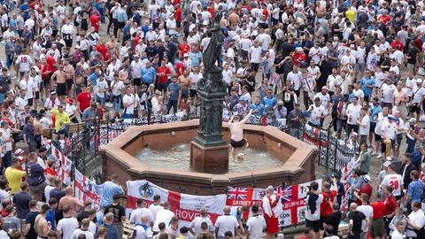 Englische Fans feiern auf dem Römerberg, ein Mann ohne Hemd spielt mit einem Ball im Justitiabrunnen.