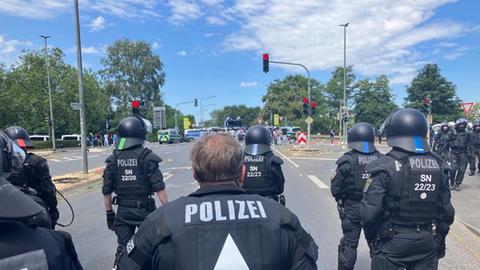 Das Bild zeigt neun Polizeibeamte mit Schlagstöcken und Helmen von hinten.