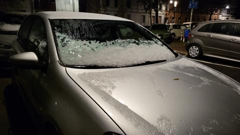 Schnee liegt auf einer Winschutzscheibe eines Autos