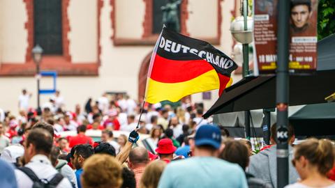 Eine Deutschlandfahne wird auf dem Frankfurter Römerberg geschwenkt.