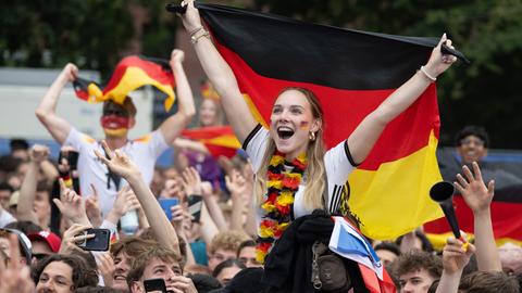 Frau auf Schultern mit Deutschland-Fahne