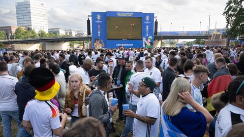 Widzowie ubrani w koszulki reprezentacji Niemiec stoją nad brzegiem Menu w strefie kibica.