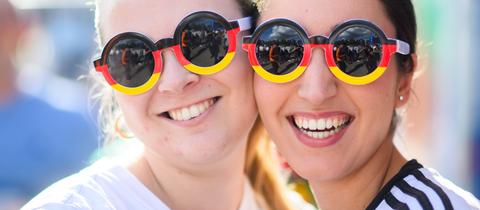 Zwei Fans mit schwarz-rot-goldenen Sonnenbrillen