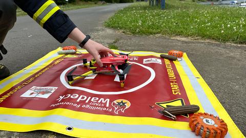 Eine gelb-rote Drohne der Waldecker Feuerwehr mit Feuerwehraufschrift steht auf einer roten Abhebe-Plane.
