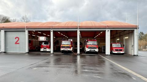 Eine Halle mit zeltartigem Dach und sechs teilweise offenen Toren, in denen man Feuerwehrautor erkennen kann