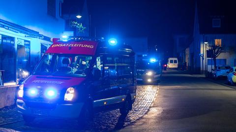 Feuerwehrautos mit Blaulicht stehen im Ortskern von Florstadt. Es ist Nacht.