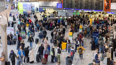 Lange Warteschlangen an den Flugschaltern und viele Menschen mit Koffern. 