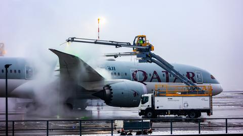 Eine Maschine ist umnebelt, das Flugzeug wird enteist in der Enteisungsanlage. 