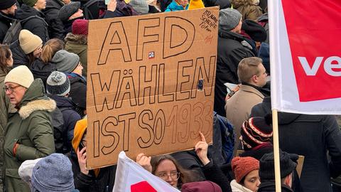 Protestierende Menschen halten Schilder hoch: "AfD wählen ist so 1933" steht auf einem. 